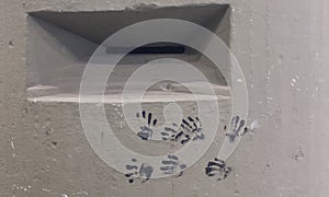 Embrasure in a concrete bunker with black handprints photo