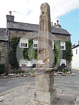 Central village square with ancient pillar and old picturesque houses in the village of cartmel in cumbria