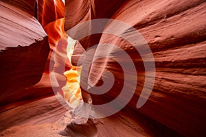 Centuries-old colorful sandstones stacked in layered fire waves in a narrow sandy labyrinth in Lower Antelope Canyon in Page