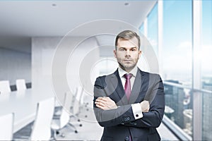 CEO with crossed hands in the modern conference room. A concept of successful business.