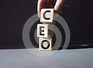 CEO - hief executive officer symbol. Concept word CEO on wooden cubes. Businessman hand. Beautiful grey background. Business and