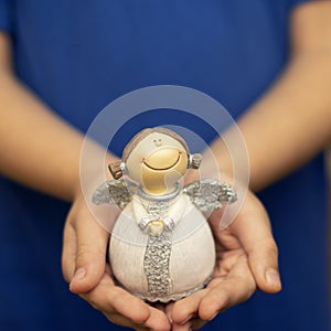 Ceramic angel in the hands of a child