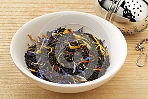 Ceramic bowl with black tea with dried flower leaves