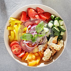 Ceramic bowl with fresh ingredients for mediterranean tomato bread salad panzanella.