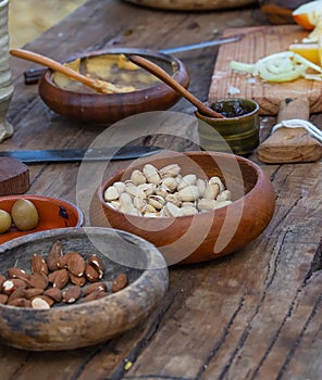 Ceramic bowl with nuts, almonds and pistachios, close-up, ceramics on a wooden table, focus on one bowl, still life