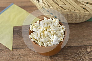 Ceramic bowl with popcorn on gray background