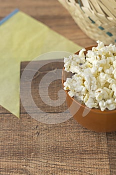 Ceramic bowl with popcorn on gray background