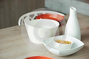 Ceramic bowl with raw fusilli pasta and white dishes on kitchen