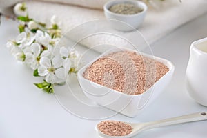 Ceramic bowl with red clay powder, ingredients for homemade facial and body mask or scrub