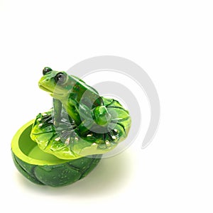 Ceramic casket for storing small items. A lid in the form of a water lily leaf on which a green frog sits. Big shiny eyes, gilded