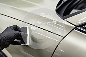 Ceramic coating application on car body panel using applicator during professional car detailing