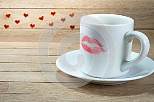 Ceramic coffee cup with lipstick mark on wood background