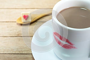 Ceramic coffee cup with lipstick mark on wood background