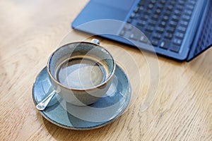 Ceramic Coffee Cup on Wooden Table with Laptop. Workspace