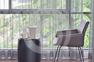 Ceramic coffee set on top of table with dark brown leather chair