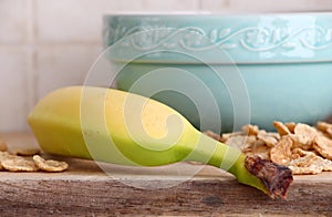 Ceramic cup, cereals flakes and a banana