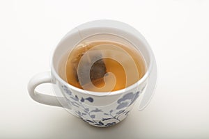 Ceramic cup of green tea with tea bag in hot water