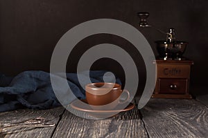 Ceramic Cup and saucer, teaspoons, hand mill for coffee, on black background