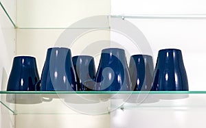 Ceramic cups on glass shelf