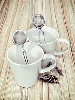 Ceramic cups with tea strainers and tea bags