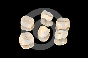 Ceramic dental crowns and veneers. Isolate on a black background close-up. Dental laboratory
