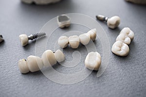 Ceramic dentures and crowns on gray background