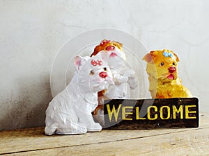 Ceramic dog with welcome sign on wooden background