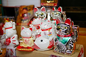 Ceramic doll of Japanese welcome or lucky cat that placed in the box shelf for sell in the souvenir shop