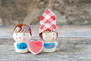 Ceramic dolls sweetheart on wooden background.