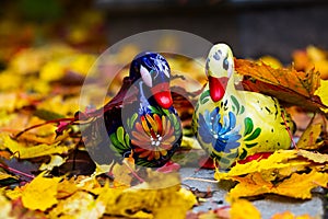 Ceramic duck painted in Zhestovo (Russia) on the background of autumn leaves