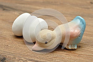 A ceramic duck with white easter eggs