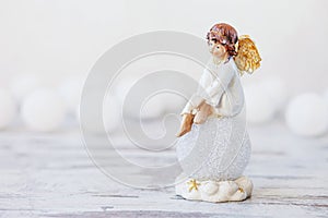 Ceramic figure of angel on light background. Copy spase