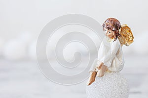 Ceramic figure of angel on light background. Copy spase