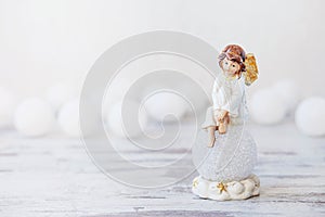 Ceramic figure of angel on light background. Copy spase