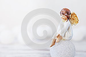 Ceramic figure of angel on light background. Copy spase