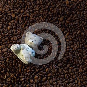 Ceramic figurine of a bear on a background of coffee beans