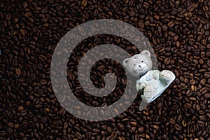 Ceramic figurine of a bear on a background of coffee beans