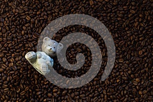 Ceramic figurine of a bear on a background of coffee beans