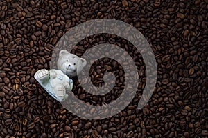 Ceramic figurine of a bear on a background of coffee beans
