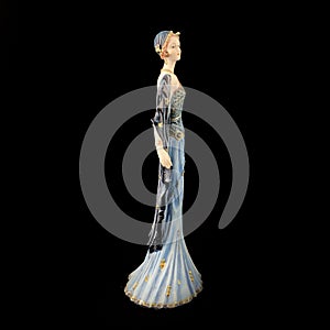 Ceramic figurine of a fantastic woman in a blue dress on a black background. porcelain antique figurine of a woman in retro clothe