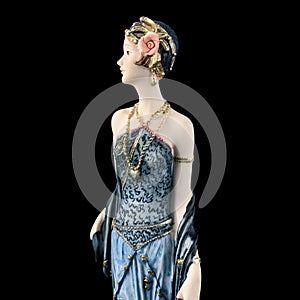 Ceramic figurine of a fantastic woman in a blue dress on a black background. porcelain antique figurine of a woman in retro clothe