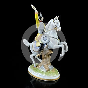 Ceramic figurine of a male commander on a horse on a black background.