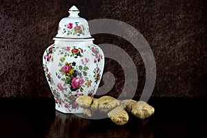 Ceramic Ginger Jar with Fresh Ginger on a Wooden Table Top