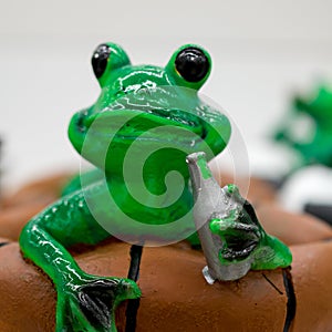 Ceramic green frog in a frivolous pose