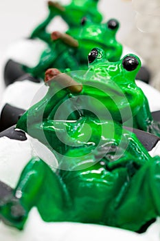 Ceramic green frog in a frivolous pose