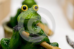 Ceramic green frog in a frivolous pose photo