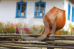 Ceramic jug on dries on the fence