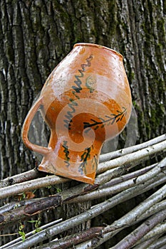 Ceramic jug on dries on the fence