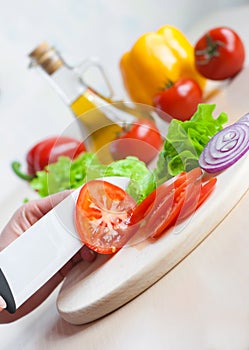 Ceramic knife chopping tomatoes for salad