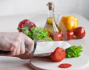 Ceramic knife cutting tomatoes for salad